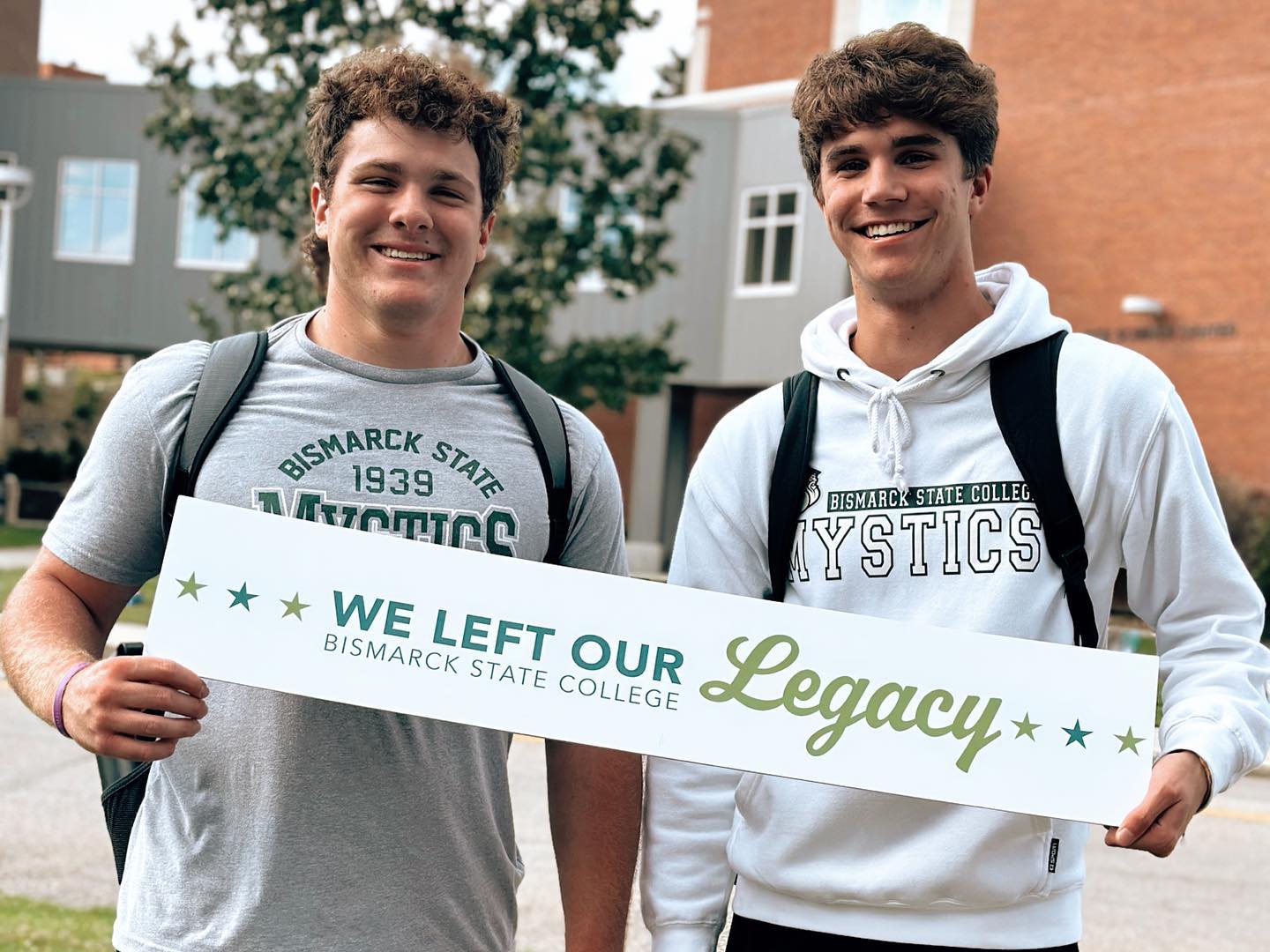 Graduates holding a sign - We Left Our Legacy