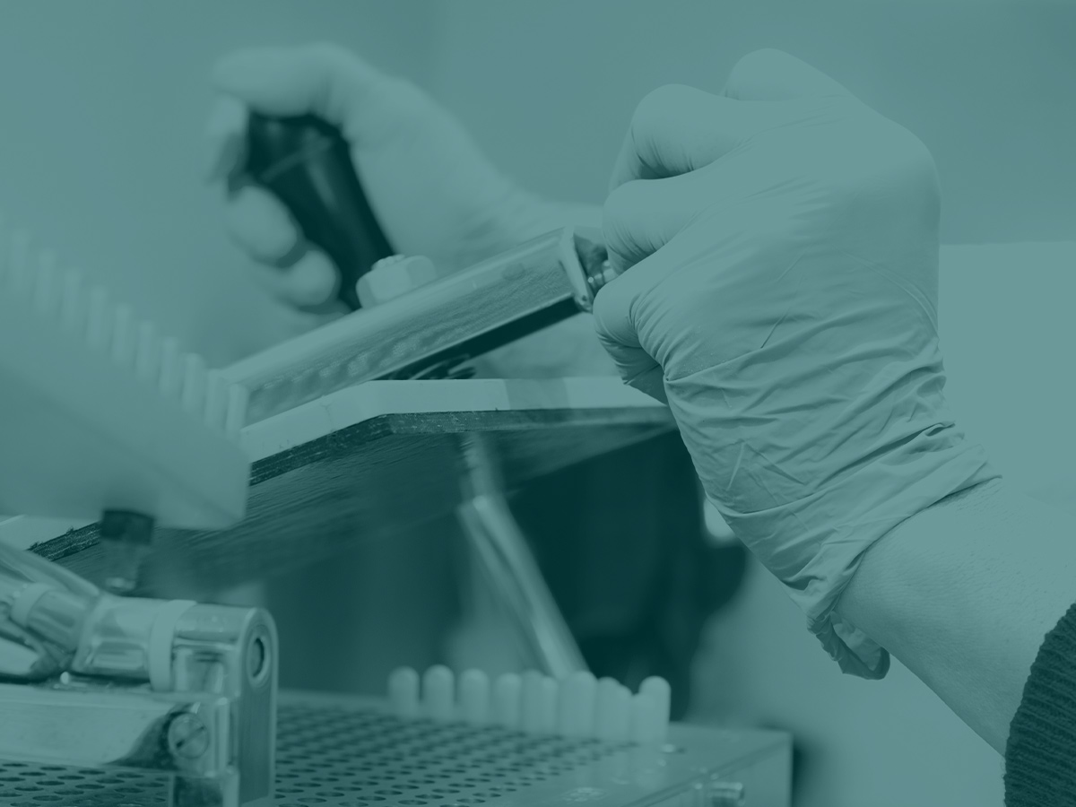 Close up of gloved hand working in lab