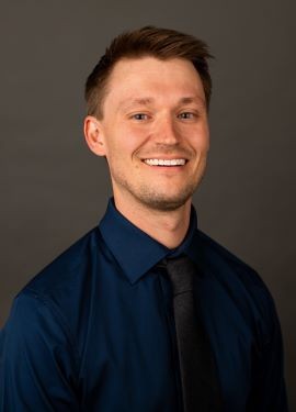 Dr. Persson, light brown hair, wearing a professional blue shirt 